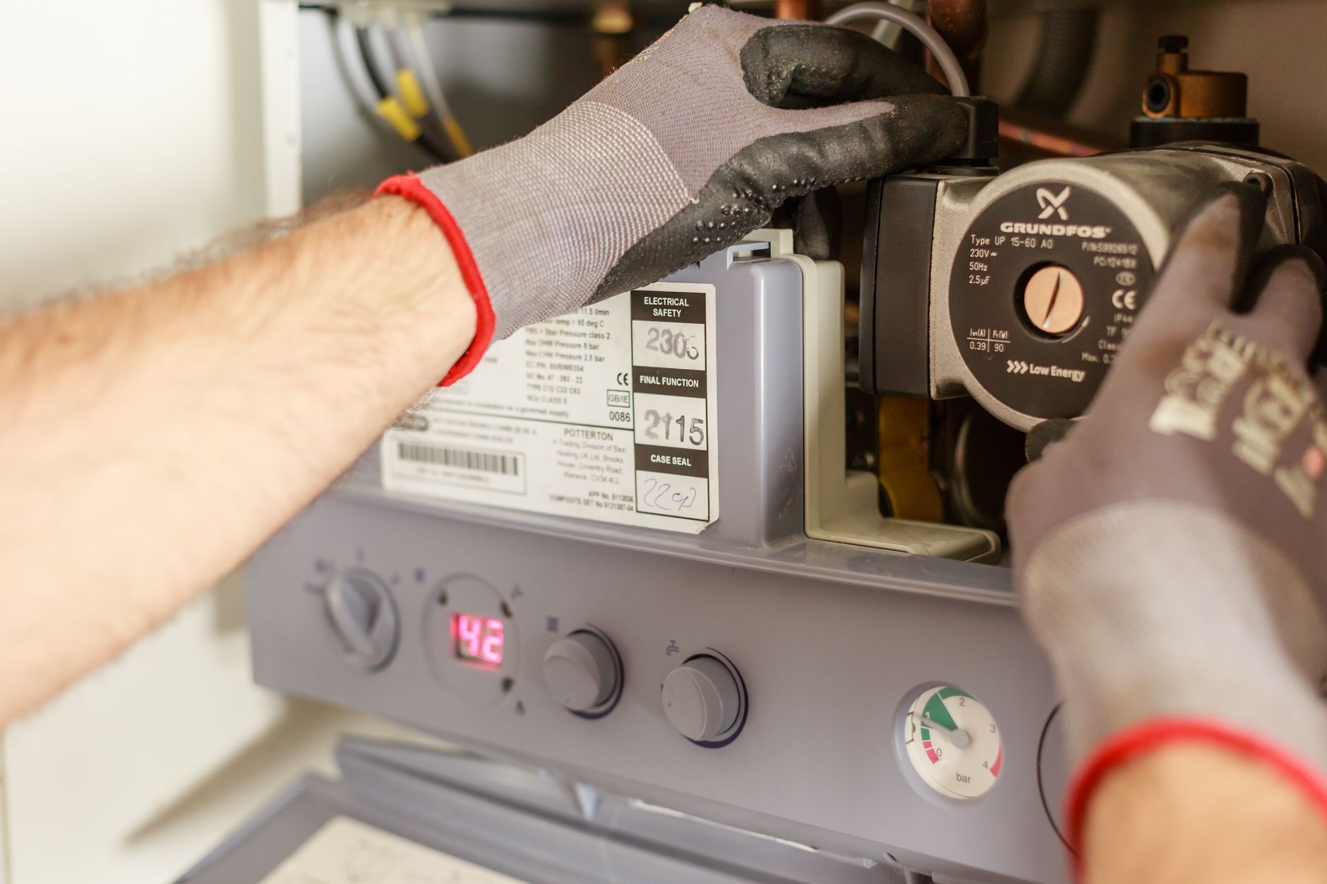 Hands adjusting a boiler system during maintenance